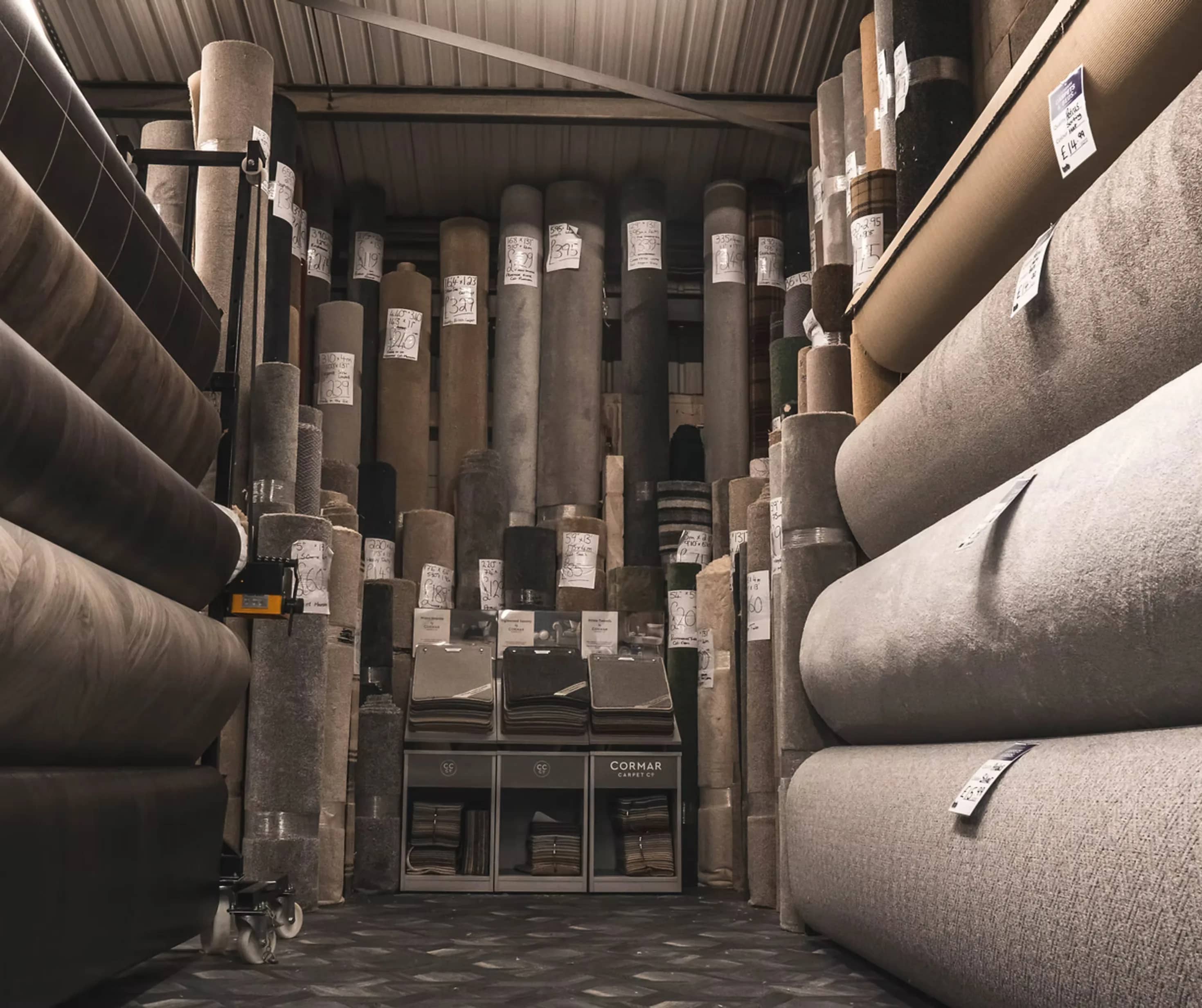 Rolls of carpet racked in the Boundary Carpets and Beds stockroom in Colne